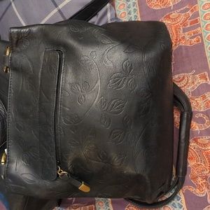 A black purse with a leaf l design